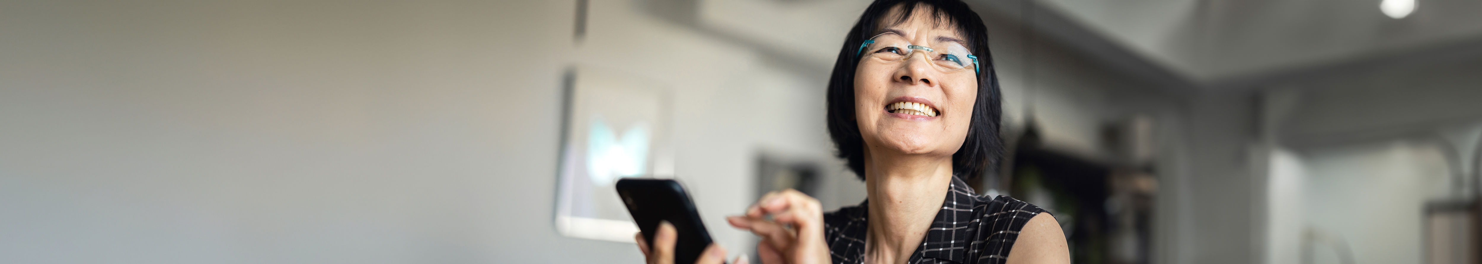 A vietnamese woman smiling holding phone