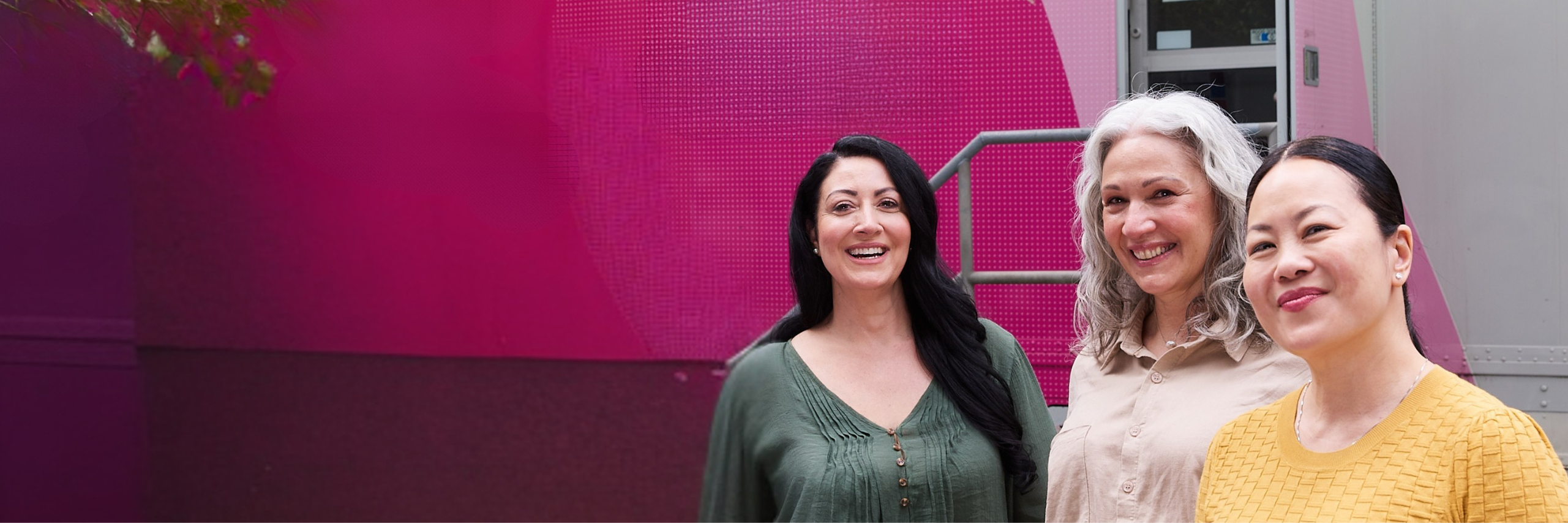 Women smiling in front of BreastScreen NSW mobile van